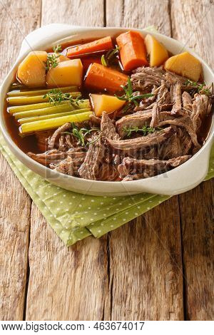 Delicious Beef Pot Roast With Potatoes, Celery And Carrots With Thyme And Rosemary Closeup In The Bo