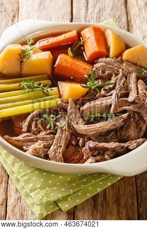 Homemade Slow Cooker Pot Roast With Carrots, Celery And Potatoes Closeup In The Bowl On The Wooden T