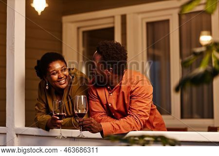 Portrait Of African American Couple Chattting On House Terrace At Night