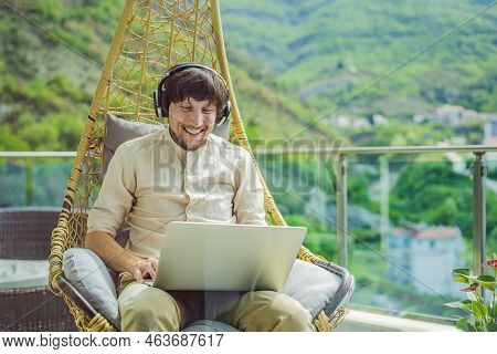 Handsome Caucasian Man Sitting On The Terrace Working From Home Using Computer Laptop. Young Man Tea