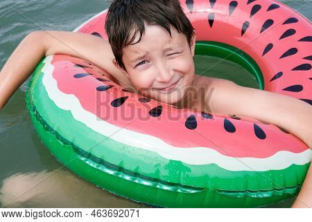 A Young Playful Happy Teenage Boy Relaxing On An Inflatable Ring , Floaty In The Sea During Summer V