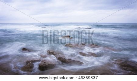 Rough wave crashing on ocean rocks
