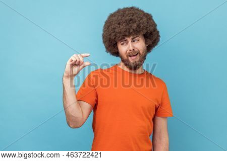 Not Very Much. Portrait Of Man With Afro Hairstyle Wearing Orange T-shirt Shapes Little Gesture, Dem