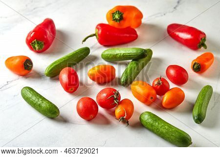 Mini Vegetables On White Marble Ready To Cook And Eat. Cherry Tomatoes, Mini Cucumbers And Mini Pepp