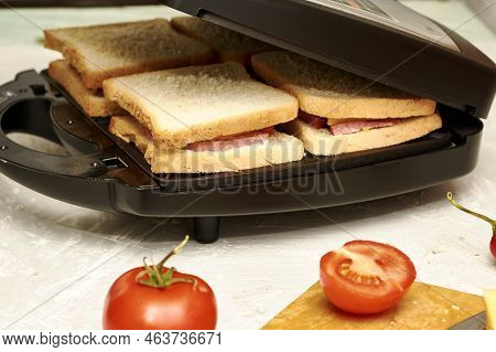 A Man Making Sandwiches In A Sandwich Maker Closes The Lid Of A Sandwich Maker