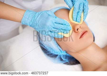 Beautician Cleanses Skin Of Beautiful Woman With A Sponge.