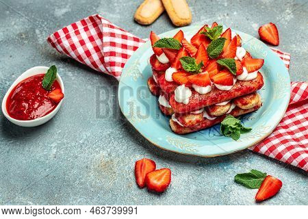 Italian Dessert Tiramisu Cake With Fresh Strawberry, Biscuit And Whipped Cream And Mint On A Dark Ba