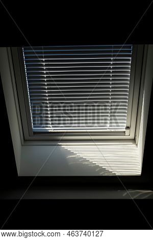 A Front Portrait Of A Velux Roof Window With A Half Open Jalousie In It To Keep The Sun And Warmth O