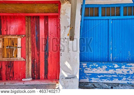 Colorful Blue, Red Boat Garage Doors, Klima Fishermen Village, Greece. Painted And Weathered Wooden 