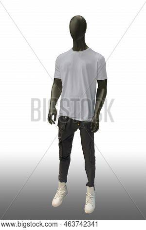 Full Length Image Of A Male Display Mannequin Wearing White T-shirt And Black Cargo Pants Isolated O