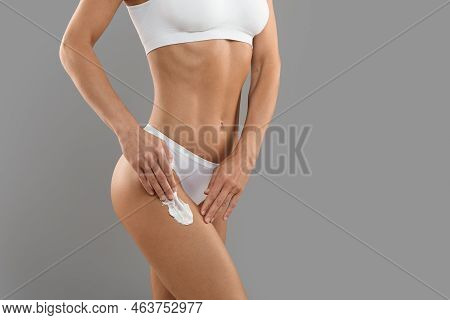 Cropped Shot Of Young Female In White Underwear Applying Body Lotion