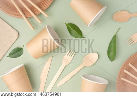 Eco - Friendly Tableware On Green Background. Top View. Plastic Free Set Of Brown Paper Utensil. Str