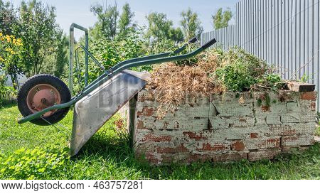 Old Metal Garden Trolley In A Garden. Garden Cleaning Equipment. An Old Empty Garden Cart In Close-u