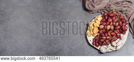 Snack Plate With Cheese, Grapes And Dried Sausages. Charcuterie Antipasto, Stone Concrete Background