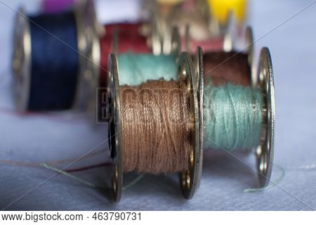 Multicolored Threads On The Bobbin From The Sewing Machine On A Blurred Background From The Other Bo