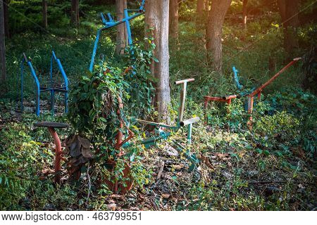 Old Outdoor Exercise Equipment So Worn Out And Covered In Trees In Outdoor Exercise Park. Old Abando