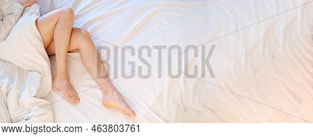 Slim, Perfect And Beautiful Crossed Womans Legs On Bed. Cropped Image Erotic Woman Lying On The Bed 