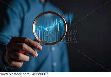 Stock Market For Analysis Technical Grap. Businessman Hand Holding Magnifier Glass With Virtual Stoc