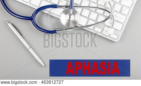 Aphasia Word With Stethoscope On A Keyboard On Grey Background