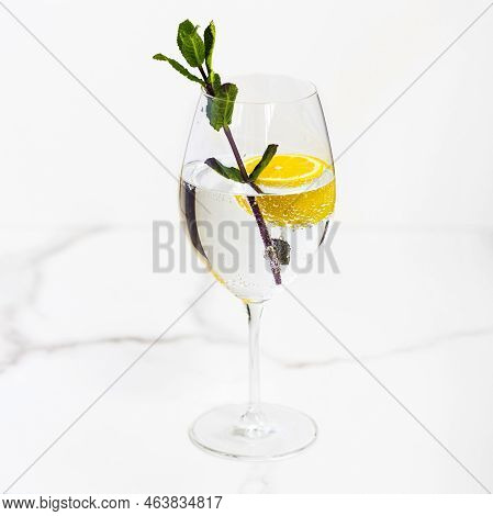 A Glass Of Water, Lemon And Mint On A White Table For Healthy Life, Energy, Thermoregulation And Nor