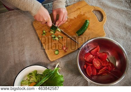 Overhead View Chopping Fresh Organic Cucumber On Wooden Cutting Board. Healthy Eating. Making Raw Ve