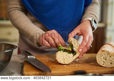 Details: Womans Hands Put Greens And Organic Fresh Vegetables In The Bread, Making Crusty Sandwiches
