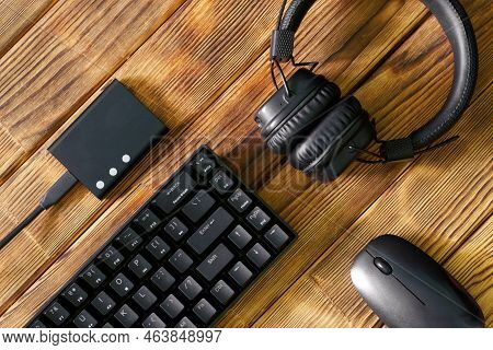 Compact Black Gaming Computer Keyboard, Headphones, External Ssd And Computer Mouse On A Table Made 