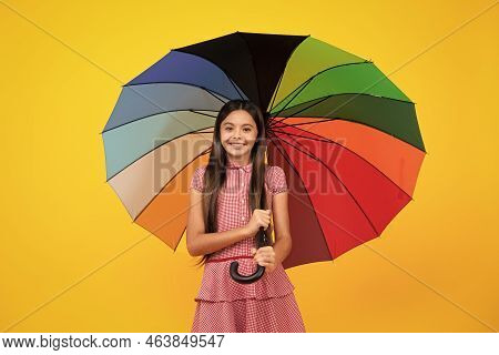 Summer Dress. Happy Teen Girl Holding Rainbow Umbella Standing Isolated On Yellow Background, Isolat