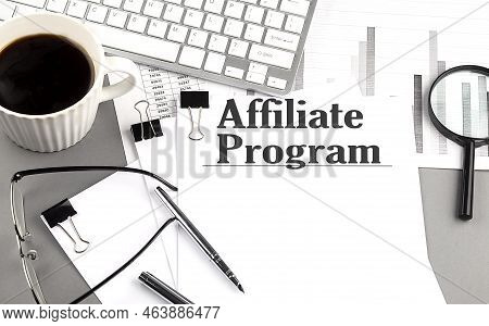 Affiliate Program Text On A Paper With Magnifier, Coffee And Keyboard On A Grey Background