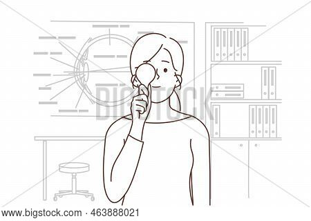 Young Woman Check Sight In Oculist Cabinet. Girl Close One Eye Examine Eyesight In Eye Doctor Clinic