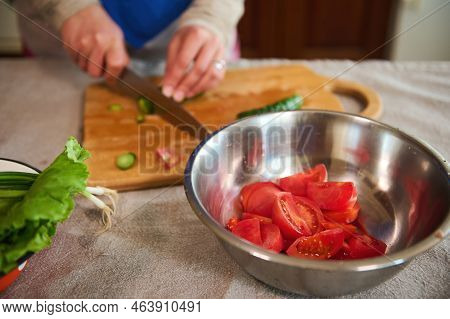 Selective Focus On A Metal Bowl With Chopped Ripe Juicy Red Tomatoes On A Kitchen Table With Linen T