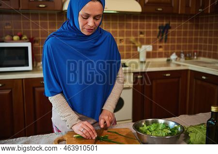 Beautiful Middle-eastern Muslim Woman, Housewife In Blue Hijab, Preparing Vegetable Salad, Chopping 
