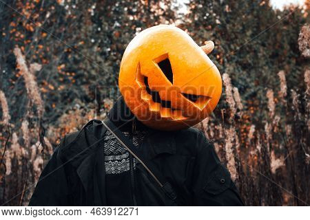 Man Portrait With An Orange Pumpkin (jack O Lantern) On His Head In A Black Jacket In The Fashion Of