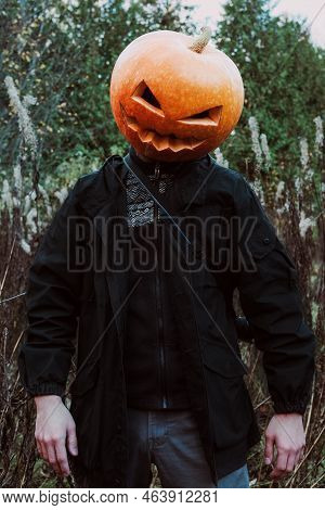 Man Portrait With An Orange Pumpkin (jack O Lantern) On His Head In A Black Jacket In The Fashion Of