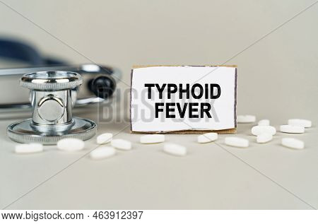 Medical Concept. On A Gray Background, A Stethoscope, Pills And A Cardboard Plate With The Inscripti