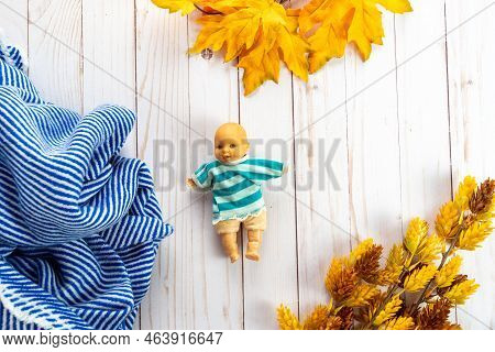 Old Plastic Mini Baby Doll Toy Wearing A Striped Sweater. Toy Is Antique From The 1980s. Flat Lay Fo