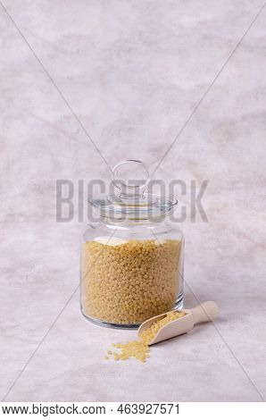 Traditional Dry Pearl Couscous In A Glass Jar On A Light Background. Selective Focus.