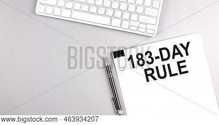 183-day Rule Text On A Paper With Keyboard On Grey Background