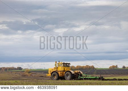 Old Model Tractor Working In The Field. Tractor Working On The Farm. High Quality Photo