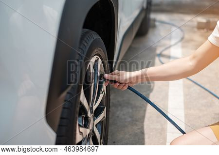 Hand Inflating Tires Of Vehicle, Checking Air Pressure And Filling Air On Car Wheel At Gas Station. 