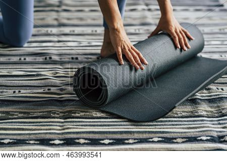 Close Up Of Female Hands Closing Yoga Mat At Home After Full Session Of Healthy Lifestyle Workout At