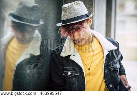 Side Portrait Of Trendy Male Boy Teenager With Violet Hair And Hat In Outdoor Urban Leisure Activity
