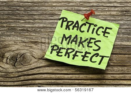 practice makes perfect - a motivational reminder on a green stocky note against grained wood