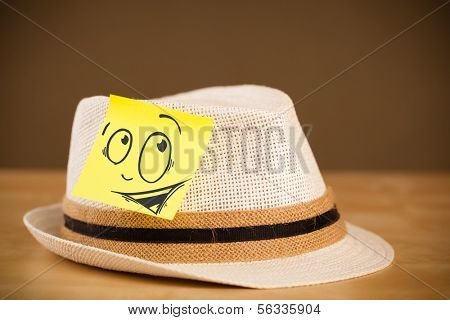 Drawn smiley face on a post-it note sticked on hat