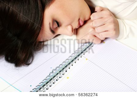 Young tired student fallen asleep at the table