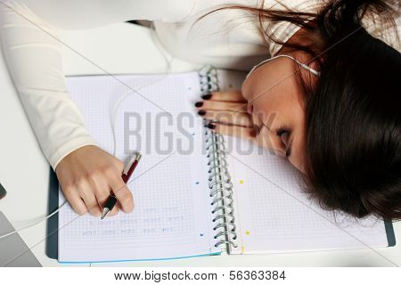 Young tired student fallen asleep at the table