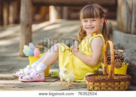 Happy little girl playing with the chickens outdoors in the countryside.
