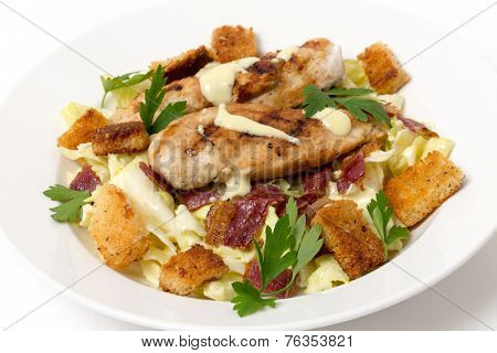 Chicken caesar salad, grilled chicken breast on a bed of lettuce tossed in a parmesan flavoured garnished with croutons, bacon bits and italian flat-leaf parsley.