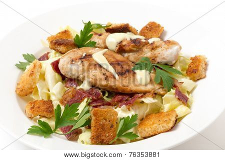 Chicken caesar salad, grilled chicken breast on a bed of lettuce tossed in a parmesan flavoured garnished with croutons, bacon bits and italian flat-leaf parsley.