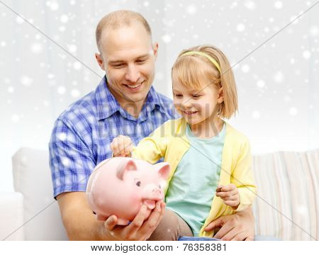family, children, money, investments and happy people concept - happy father and daughter with big pink piggy bank